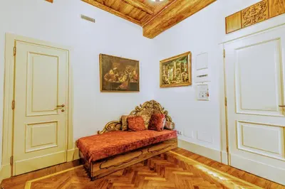 a room with a bench and paintings on the wall at Casa Arpinelli in Rome