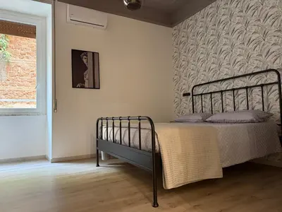 a bedroom with a bed and a wall at Apartment Aurum Colosseum in Rome