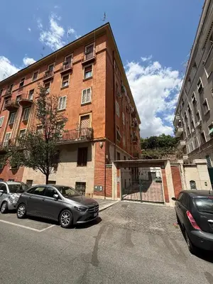 two cars parked in front of a brick building at Apartment Aurum Colosseum in Rome