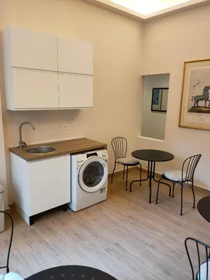 a kitchen with a washing machine and a table at Igg VATICAN HOLIDAY in Rome