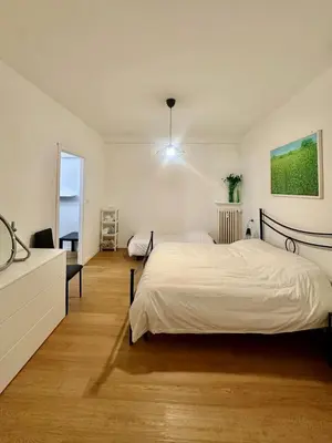 a bedroom with two beds and a desk and a window at San Lorenzo vivace e giovanile in Rome