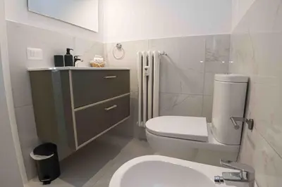a bathroom with a white toilet and a sink at Nexus Prati Suite in Rome