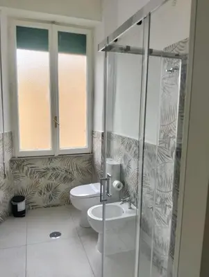 a bathroom with a toilet and a glass shower at Nexus Prati Suite in Rome