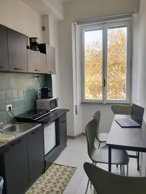 a kitchen with a table with a laptop on it at Nexus Prati Suite in Rome