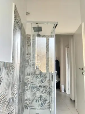 a shower with a glass door in a room at Nexus Prati Suite in Rome