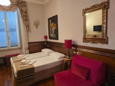 a bedroom with a bed and a chair and a mirror at Chez Oriana Termini St in Rome