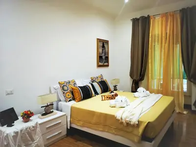 a bedroom with two beds and a yellow blanket at Have A Nice Holiday - Luxury Rooms in Rome