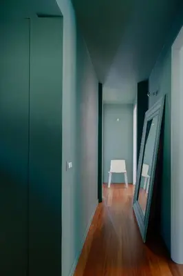 a hallway with a white chair and a mirror at Emanuela Home - VATICAN in Rome