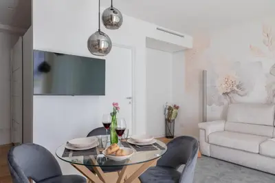 a living room with a glass table and chairs at iFlat Modern Sunlit Studio Apt by the Colosseum in Rome
