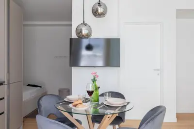 a dining room with a glass table and chairs at iFlat Modern Sunlit Studio Apt by the Colosseum in Rome