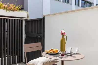 a table with a plate of food and a vase of flowers at iFlat Modern Sunlit Studio Apt by the Colosseum in Rome