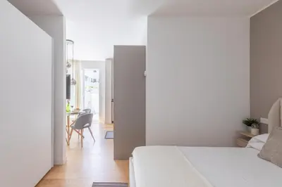 a bedroom with a bed and a dining room at iFlat Modern Sunlit Studio Apt by the Colosseum in Rome