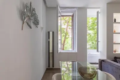 a living room with a glass table and a window at iFlat Sleek & Sunlit Apartment near the Vatican in Rome