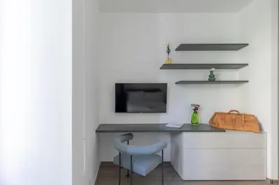 a desk with a chair and a television on a wall at iFlat Sleek & Sunlit Apartment near the Vatican in Rome