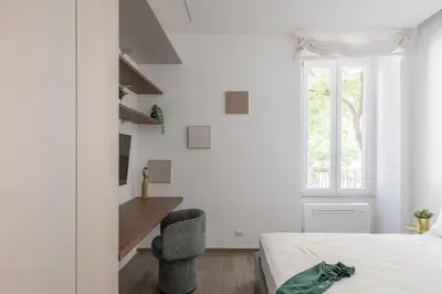 a white bedroom with a bed and a window at iFlat Sleek & Sunlit Apartment near the Vatican in Rome