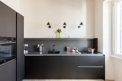 a black kitchen with a sink and a stove at iFlat Peaceful & Charming Hideaway near Vatican in Rome