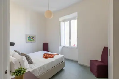 a white bedroom with a bed and a window at iFlat Calm & Spacious Apartment in Urban Oasis in Rome