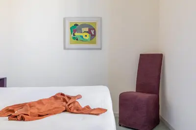 a blanket on a white couch next to a chair at iFlat Calm & Spacious Apartment in Urban Oasis in Rome