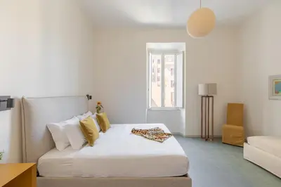 a white bedroom with a bed and a couch at iFlat Calm & Spacious Apartment in Urban Oasis in Rome