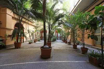 a hallway with palm trees in pots in a building at 23 FREE ROME Trastevere in Rome