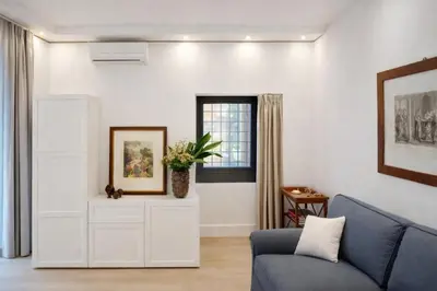 a living room with a couch and a window at Modern Flat Historic 1200s Palace Steps from Navona in Rome