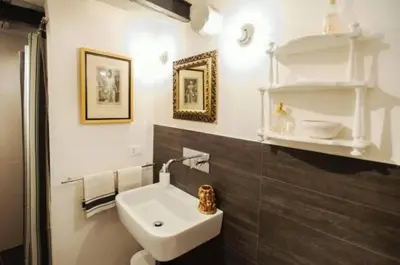a bathroom with a sink and a toilet in it at Modern Flat Historic 1200s Palace Steps from Navona in Rome