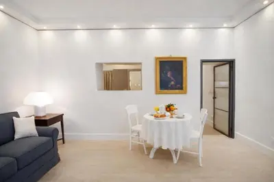 a living room with a table and a couch at Modern Flat Historic 1200s Palace Steps from Navona in Rome