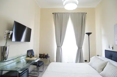a bedroom with a bed and a desk and a window at Town House 57 in Rome