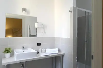 a white bathroom with a sink and a shower at Town House 57 in Rome