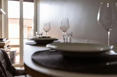 a table with three wine glasses and a plate on it at LA PETITE MAISON a ROME in Rome