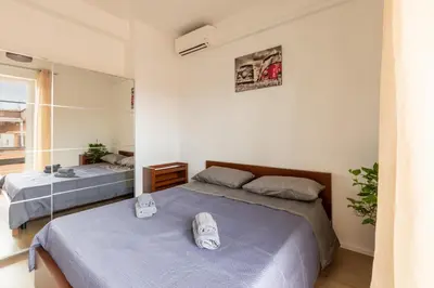 a bedroom with two beds and a mirror at LA PETITE MAISON a ROME in Rome