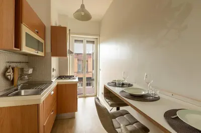 a kitchen with a table with two glasses on it at LA PETITE MAISON a ROME in Rome
