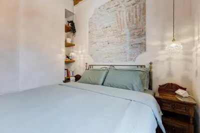 a bedroom with a white bed and a brick wall at Mazza Stay in Rome
