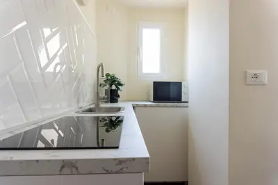 a white kitchen with a sink and a window at Rome Bliss GuestHouse in Rome