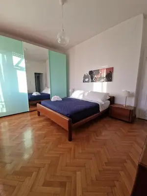a bedroom with a bed and a wooden floor at Ponte Lungo Guest House in Rome