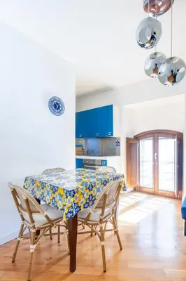 a kitchen with a table with chairs and blue cabinets at Elegante dimora - nel centro di Roma in Rome