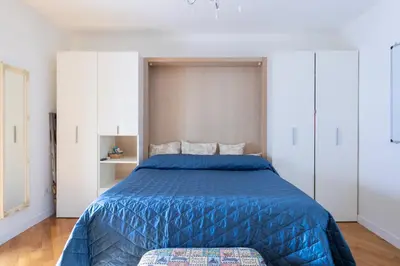 a bedroom with a blue bed and white cabinets at Elegante dimora - nel centro di Roma in Rome