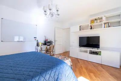 a white bedroom with a blue bed and a tv at Elegante dimora - nel centro di Roma in Rome