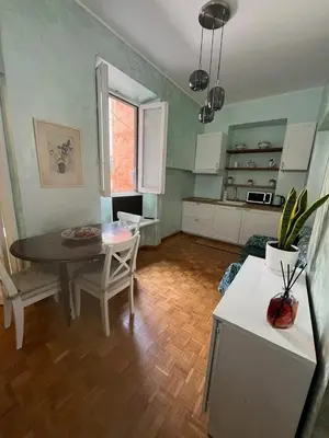 a living room with a table and a kitchen at Casa Luciano in Rome
