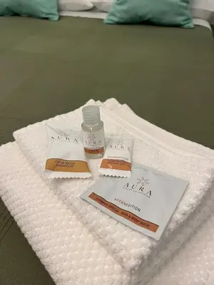a pile of towels with a bottle of medicine on a bed at Casa Luciano in Rome