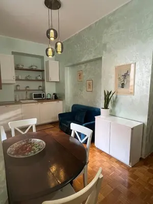 a kitchen and living room with a table and a couch at Casa Luciano in Rome