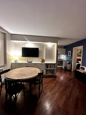 a living room with a table and a tv at Pace Blu Roma in Rome
