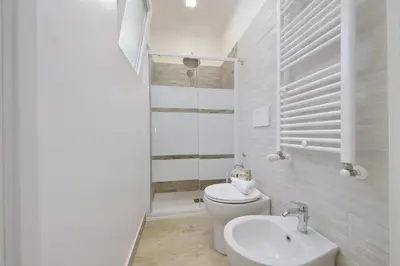a white bathroom with a toilet and a sink at Michele Lux Lodge 6 people Spotless and Connected to Airport and Vatican in Rome