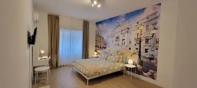 a bedroom with a bed and a large painting on the wall at Fontana di Trevi Apartment, 24h check-in in Rome