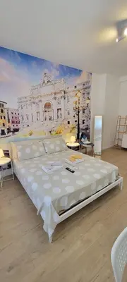 a large bed in a room with a painting on the wall at Fontana di Trevi Apartment, 24h check-in in Rome