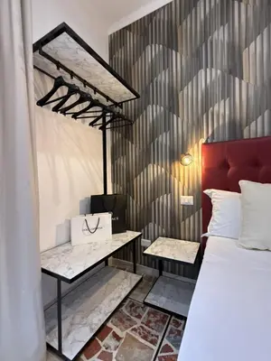 a bedroom with a bed and a bench next to a wall at Dormire in Trastevere in Rome
