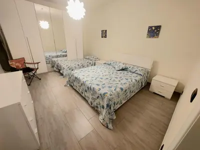 a bedroom with three beds and a mirror at La Casa dei Melograni in Rome