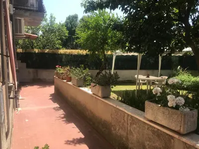 a row of potted plants on a wall with a table at La Casa dei Melograni in Rome