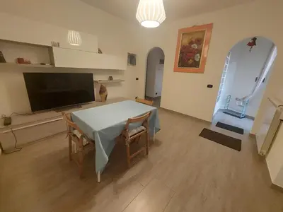 a living room with a table with chairs and a television at La Casa dei Melograni in Rome