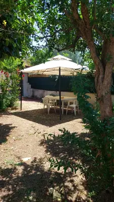 a picnic table under a white umbrella under a tree at La Casa dei Melograni in Rome